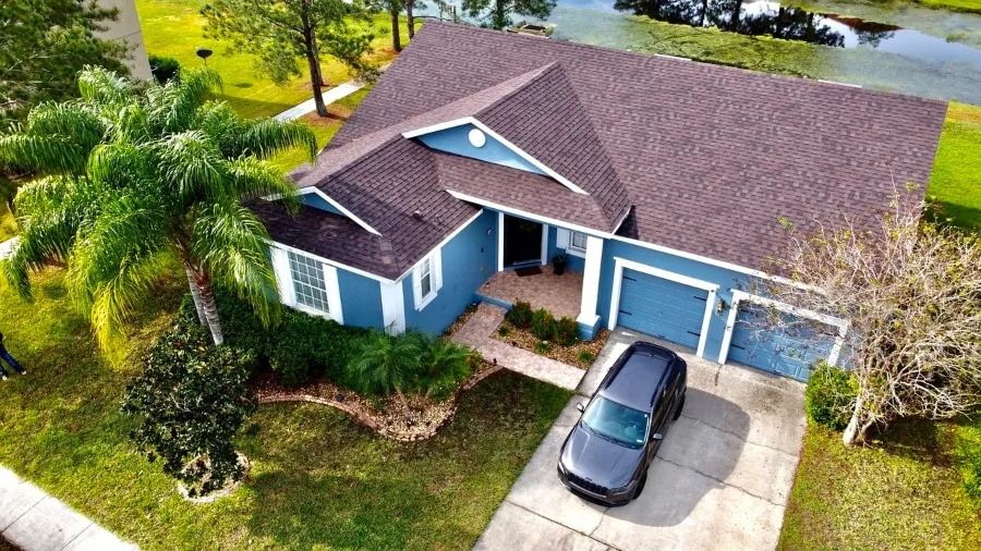 Aerial drone inspection view of a residential roof, gutters, and siding