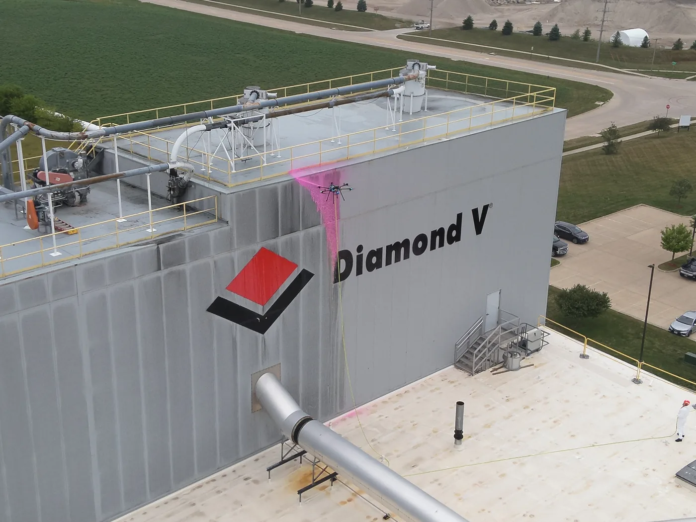 Drone cleaning the exterior wall of an industrial manufacturing plant